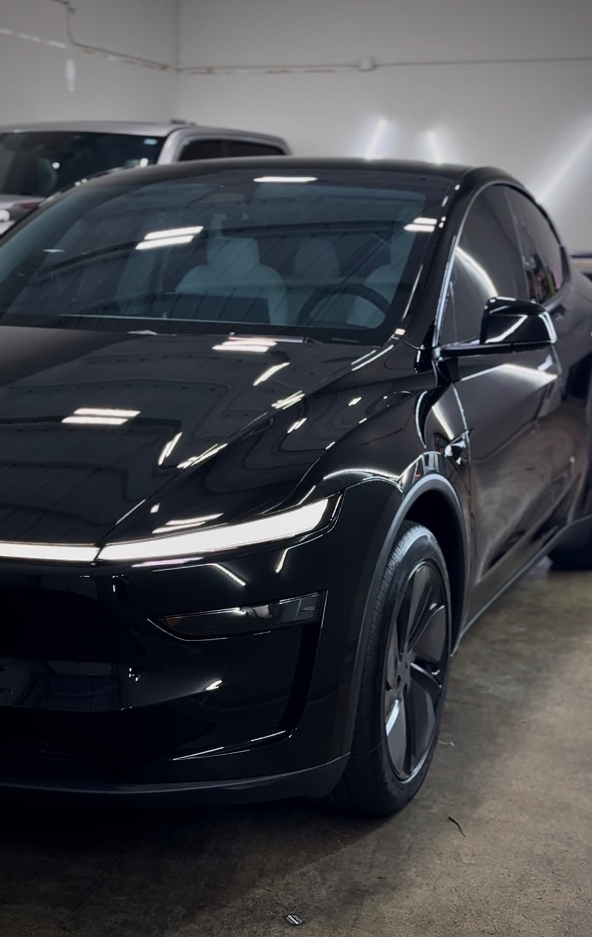Black Tesla Model X front detail under shop lights